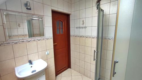 baño con lavabo y puerta roja en Gospodarstwo Agroturystyczne Domek na Wzgórzu, en Chmielnik