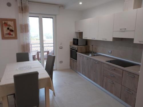 a kitchen with white cabinets and a table with chairs at Ca Giardina in Levico Terme