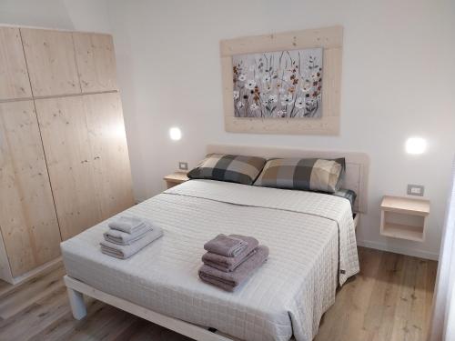 una camera da letto con un letto e asciugamani di Ca Giardina CIPAT 022104-AT-012586 a Levico Terme