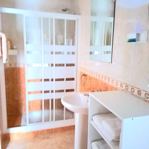 Baño blanco con lavabo y espejo en Apt. cerca de la playa y airport en Málaga