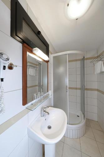 a bathroom with a sink and a shower and a toilet at Mediterranean Village San Antonio in Biograd na Moru