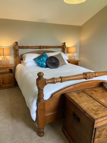 a bedroom with a large wooden bed with two lamps at Moorland Breeze in Bodmin