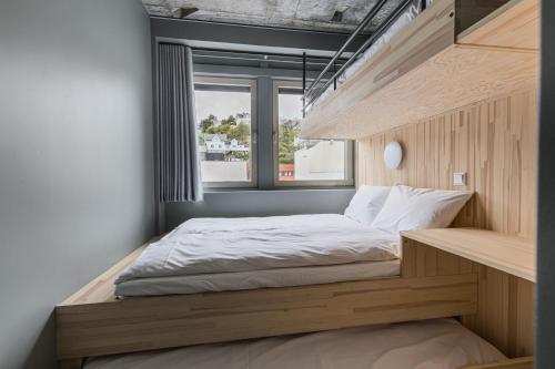 een kleine slaapkamer met een bed en een raam bij Hotell Arendal in Arendal