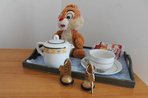a tray with a toy monkey and a tea pot and shoes at Hotel Esperia in Capri