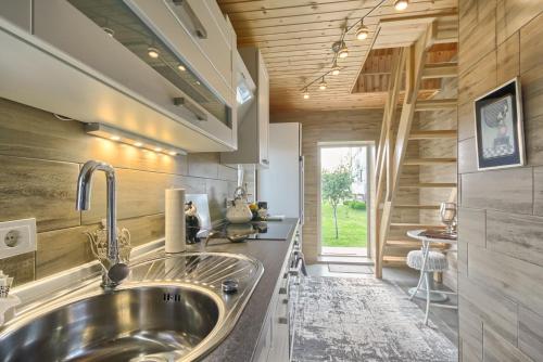 Merkinė的住宿－Dvi liepos，厨房设有不锈钢水槽和木墙