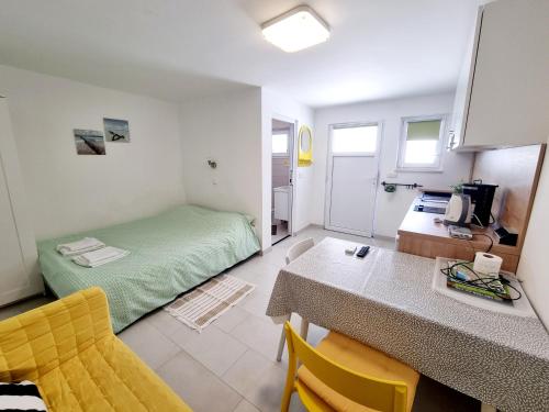 a small room with a bed and a table and chairs at ARA-ZAROK in Baška