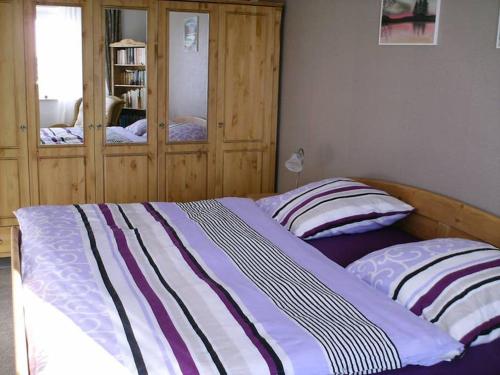 a bedroom with a bed and a wooden cabinet at Schnuckliges Apartment mit Traum-Panorama im Harz in Sankt Andreasberg