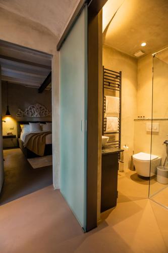 a bedroom with a bed and a bathroom with a toilet at Pietralago, Casa con vista sul Lago in Blevio