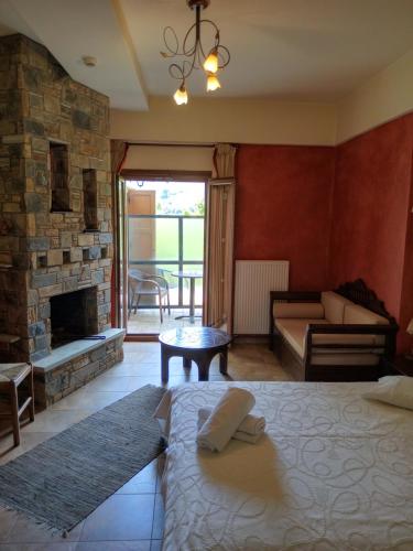 a living room with a bed and a fireplace at Hotel Erotas in Agios Dimitrios