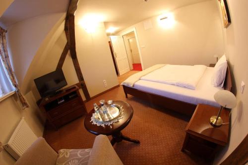 um quarto de hotel com uma cama e uma mesa em Pałac Bugaj em Raszków