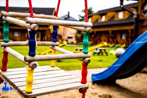 a swing in a playground with a slide at Domki Victoria in Ustka