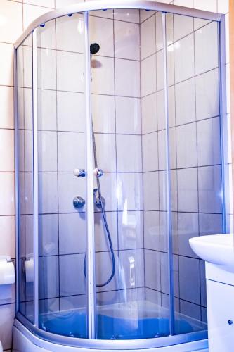 a shower with blue water in a bathroom at Domki Victoria in Ustka