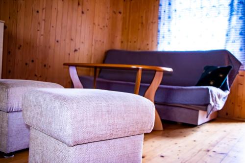 a living room with a purple couch and a table at Domki Victoria in Ustka