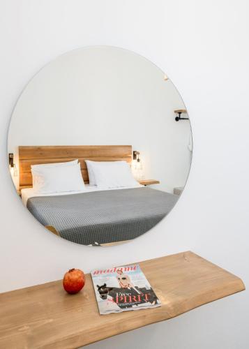a mirror over a table with a bed in a bedroom at Michalis Studios in Pollonia