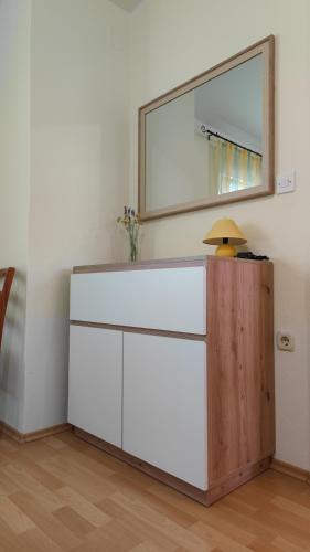 a white dresser in a room with a mirror at Apartments Bolont in Pag