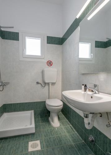 a bathroom with a toilet and a sink at Michalis Studios in Pollonia