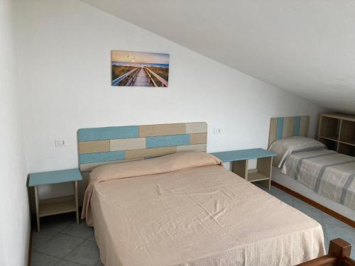 a bedroom with a bed and two tables at Parco Vacanze La Rosa dei Venti in Marina di Bibbona