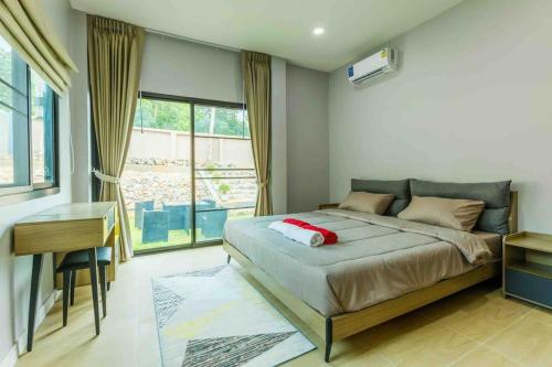 um quarto com uma cama, uma secretária e uma janela em Private Pool villa & warm water. em Ban Mae Kon