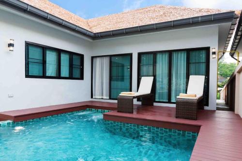 uma piscina com duas cadeiras e uma casa em Private Pool villa & warm water. em Ban Mae Kon