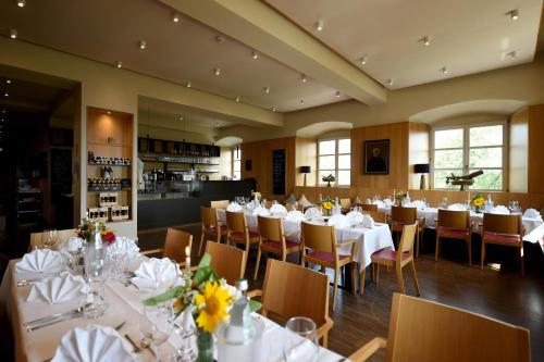 uma sala de jantar com mesas e cadeiras brancas em Kloster Frauenberg em Fulda