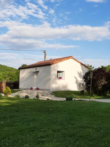 une petite maison blanche avec une cour gazonnée dans l'établissement Petite maison de campagne, à Calamane