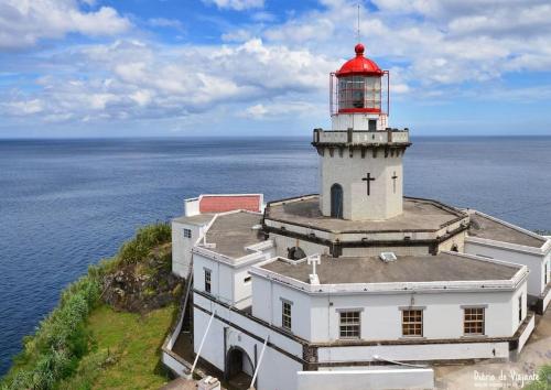 a lighthouse with a red top on top of a building at Casa da Grota do Bravo in Nordeste