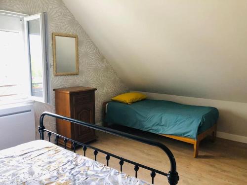 une petite chambre avec un lit et un miroir dans l'établissement Gîte Chez Paulette, à Mareuil-sur-Cher