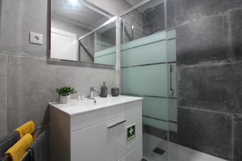 a bathroom with a white sink and a shower at Varanda do Bonfim in Setúbal