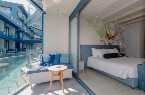 - une chambre avec un lit, une table et une piscine dans l'établissement Hotel Tide Phuket Beach front - SHA Plus, à Phuket
