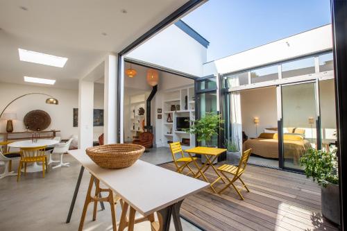 a living room with a table and chairs and a bedroom at Maison-Loft de standing autour de son patio in Vannes