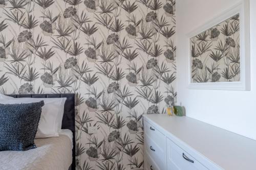a bedroom with a wall with a floral wallpaper at Holysuite Savyon View Tower in Jerusalem