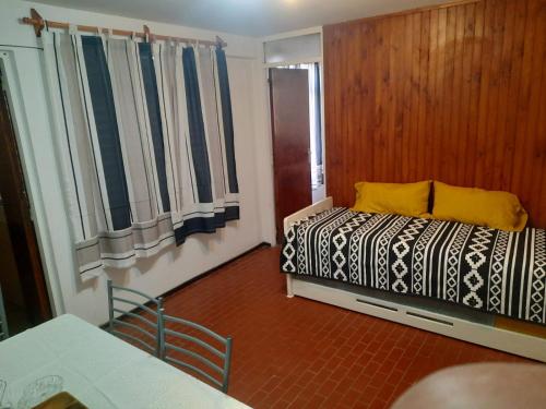 a bedroom with a bed and a table and windows at CONSORCIO ARIZU in Mendoza