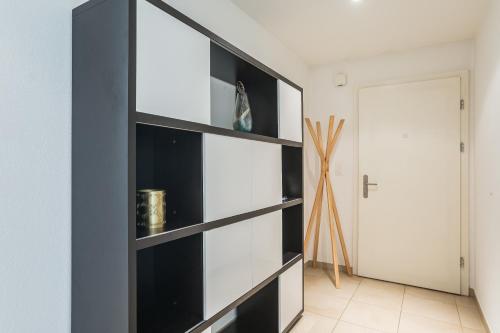 a black book shelf in a room with a door at Blonay Garden Apartment - Swiss Hotel Apartments in Blonay