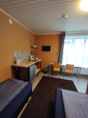 um quarto com uma cama, uma secretária e uma mesa em Room for 2 em Šiauliai