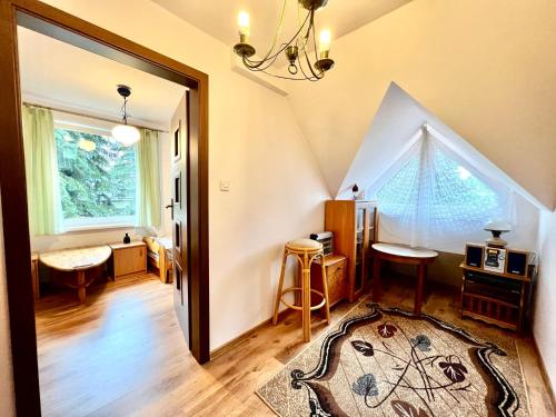 an attic room with a hallway with a rug and a window at Fantastyczny domek 5-min od jeziora Łukcze in Rogoźno