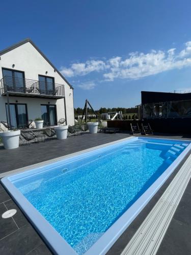 a swimming pool in front of a house at Loox Ostrovo- Boutique House-noclegi nad morzem in Ostrowo