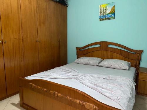 1 cama con cabecero de madera en un dormitorio en Tirana’s Elevated Apartment en Tirana