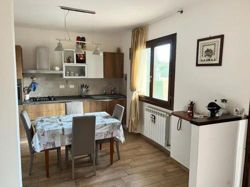 a kitchen with a table and chairs and a kitchen with a table and a window at Appartamento Altopascio sulla Francigena in Spianate