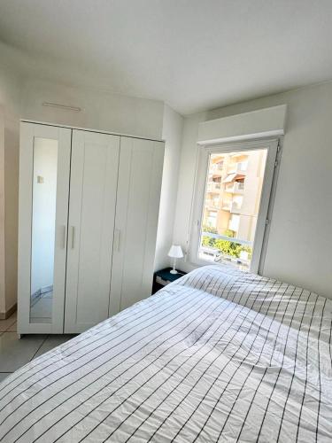une chambre blanche avec un lit et une fenêtre dans l'établissement 1 BEDROOM Plein centre JUAN LES PINS, à Antibes