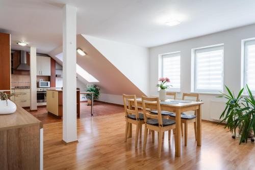 a kitchen and dining room with a table and chairs at Apartmány Frýda in Luhačovice