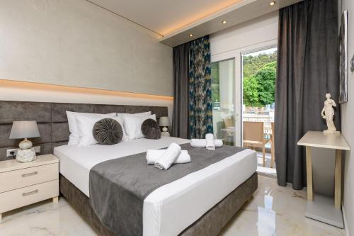 a bedroom with a large bed and a large window at Sunny Memories Apartments in Limenas