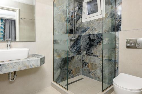 a bathroom with a shower and a toilet and a sink at Sunny Memories Apartments in Limenas