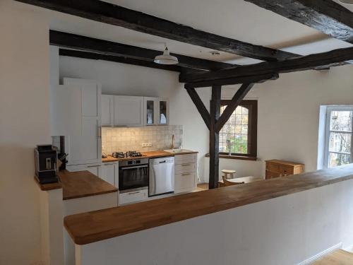 a large kitchen with white appliances and wooden beams at BacksteinFlair - LüneMitte in Lüneburg