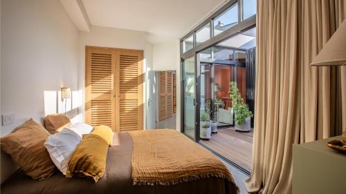 - une chambre avec un grand lit et un balcon dans l'établissement Maison-Loft de standing autour de son patio, à Vannes