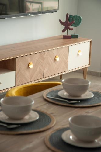 a table with three plates and a dresser at Seaview apartments in Ayios Elias
