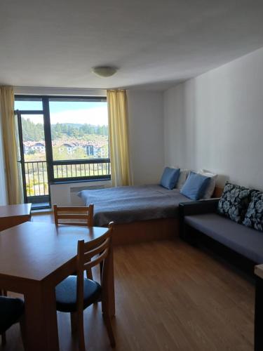 a room with a bed and a couch and a table at Аспен валей С420 in Razlog