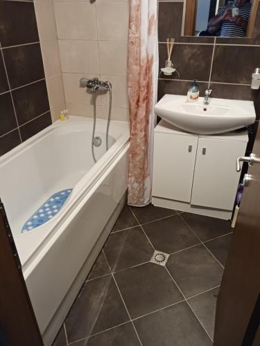 a bathroom with a bath tub and a sink at Аспен валей С420 in Razlog