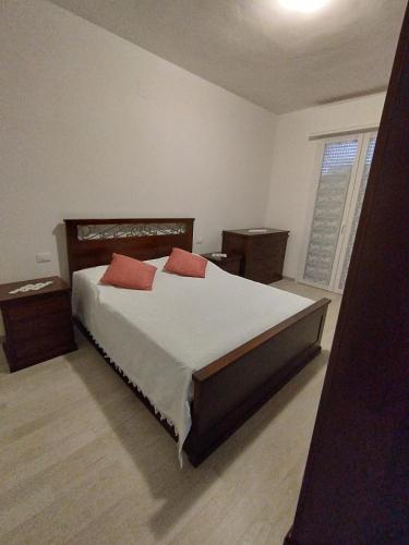 ein Schlafzimmer mit einem Bett mit zwei roten Kissen darauf in der Unterkunft Da Silvana 