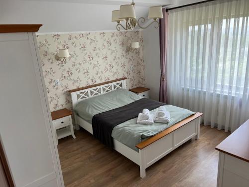 a bedroom with a bed with shoes on it at Casa Petra in Pietrăria