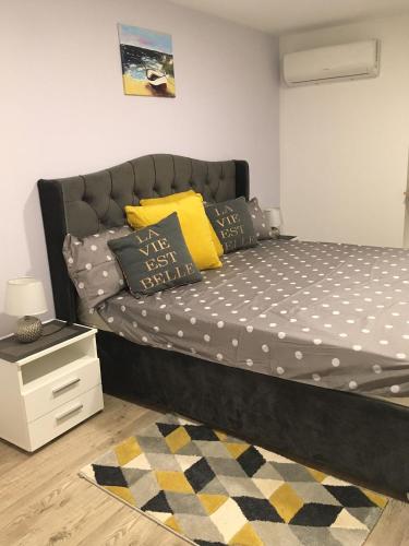 a bedroom with a bed with yellow pillows and a rug at Art De Lux apartment in Višnjan
